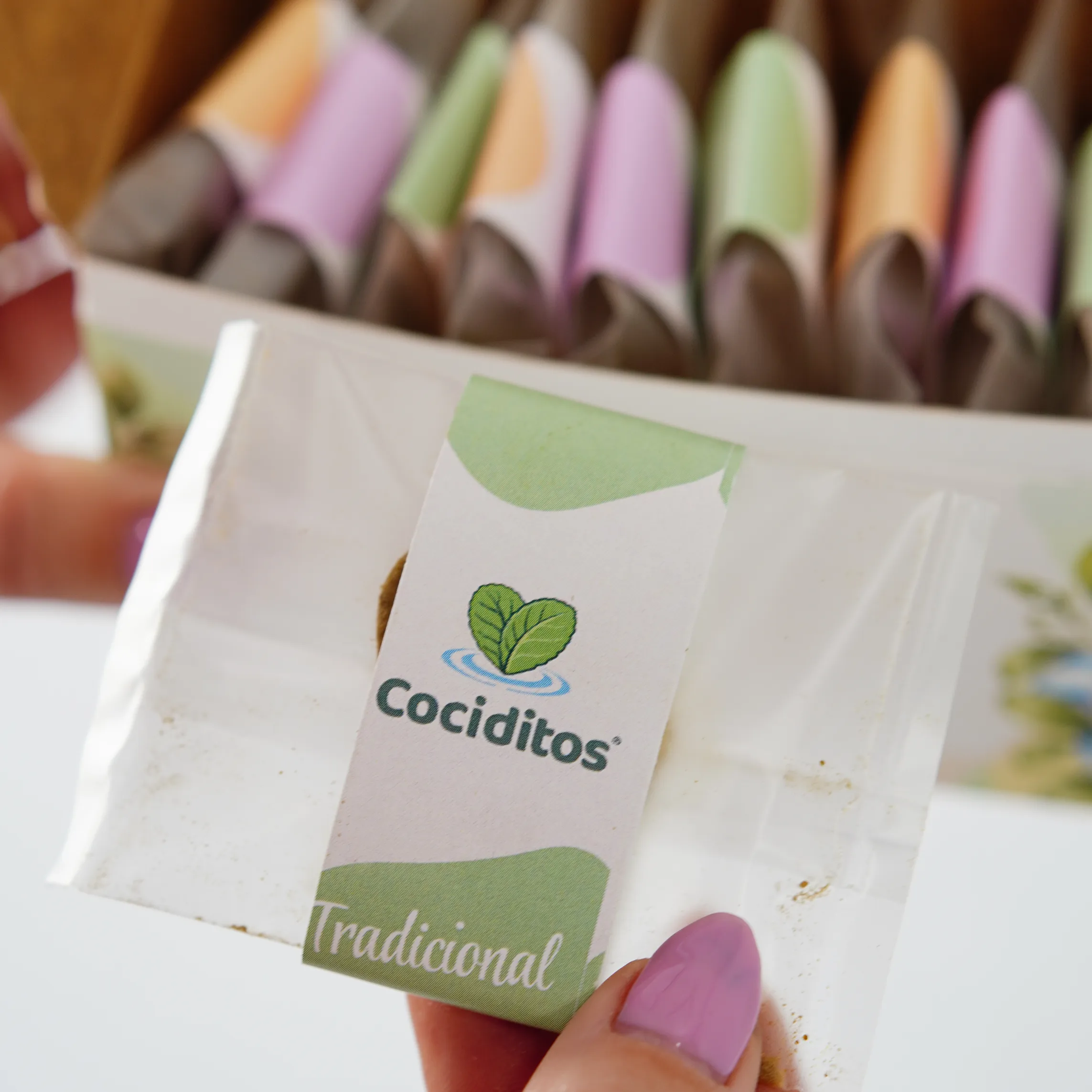 Sobre individual de Cociditos Tradicional, sostenido con una mano.
